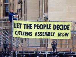 aufruf zu bürgerversammlung: aktivisten kleben sich in londoner parlament fest