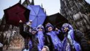 weiberfastnacht: kölner straßenkarneval beginnt im regen
