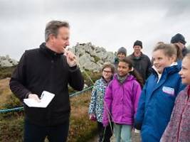 Kindergruppe ist irritiert: David Cameron knabbert an Grashalm auf den Falkland-Inseln