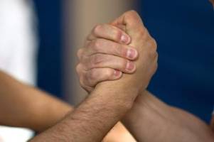 männer und frauen messen im armwrestling
