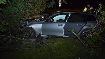 BMW durchschlägt Metallzaun und landet an Baum