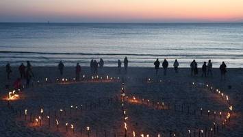 peace-zeichen: sylter erleuchten strand mit fackeln