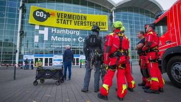 Aktivisten klettern an Messehalle hoch und spannen riesiges Banner