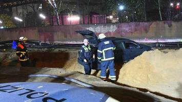 Mann schanzt im Hamburger Hafen mit seinem Auto in eine Baugrube