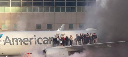 flugzeug gerät in brand, passagiere über tragflächen evakuiert