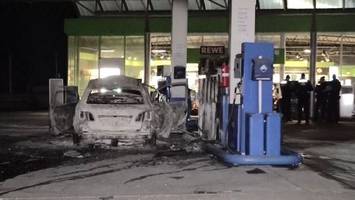 Mann fährt brennendes Auto an Tankstelle und droht mit Axt