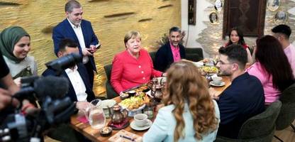 angela merkel trifft geflüchtete in syrischem restaurant