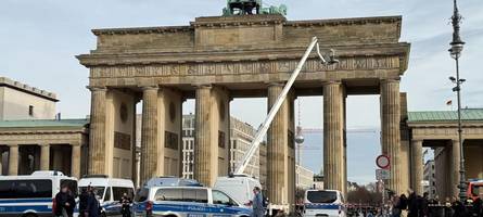 pro-palästina-demonstranten klettern auf brandenburger tor