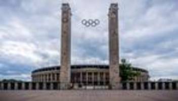 Mit Klettergeschirr: Aktivisten hängen Protest-Banner am Olympiastadion-Dach auf