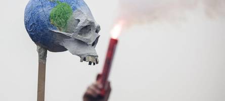 Klimaaktivisten ziehen durch die Augsburger Innenstadt und zünden Weltkugel an