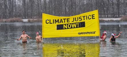 greenpeace-anhänger gehen aus protest im kuhsee baden
