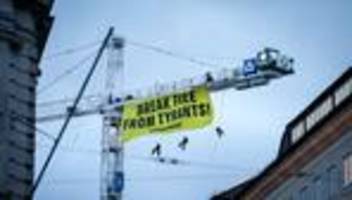 Protest: Kletterer entrollen Protest-Transparent an Kran in München