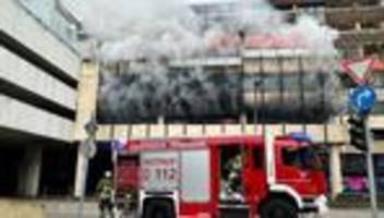 Ermittlungen laufen: Feuerwehr mit Atemschutz löscht brennendes Auto im Parkhaus