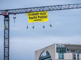freiheit statt fossile politik: greenpeace-aktivisten hängen sich von kran vor dem kanzleramt